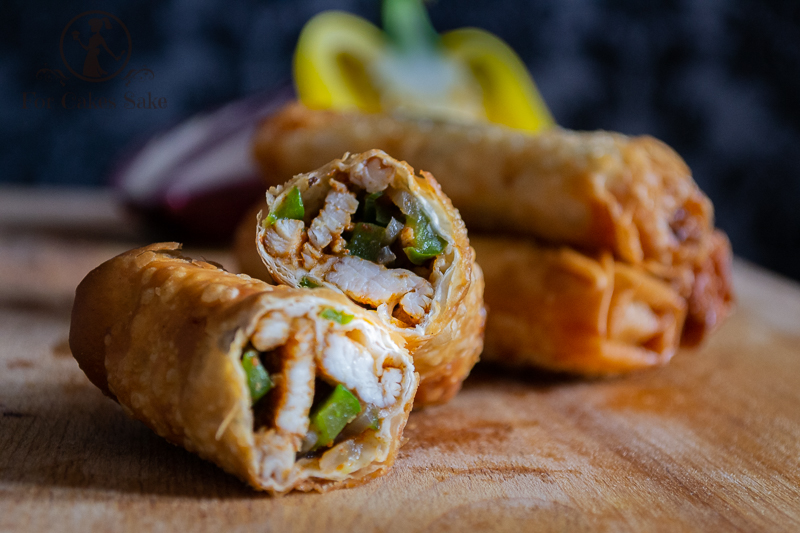 A Fajita Filo Pastry roll cut in half in front of a stack of other rolls.