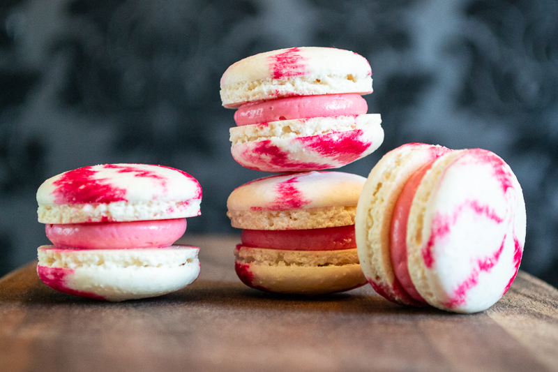 Four pink and white striped macarons.